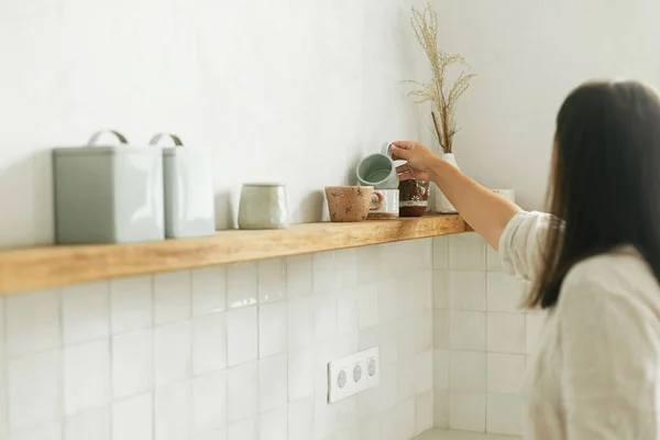 Стильна Жінка Розпаковує Прикрашає Полиці Посудом Чашками Новій Мінімальній Білій — стокове фото