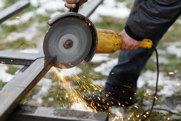 用角磨床切割金属的工人 用于焊接铁件 闭合圆磨床盘和电火花 用屏蔽金属弧焊制造栅栏的工人 — 图库照片