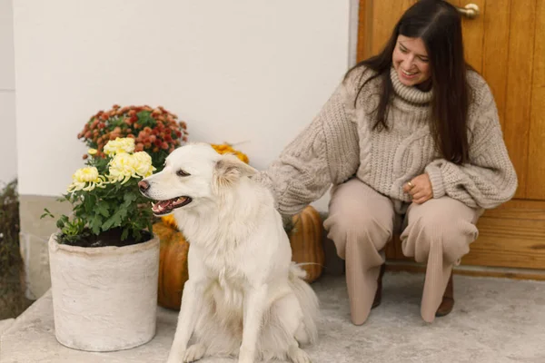 Szczęśliwa Kobieta Dzianiny Sweter Pieszczoty Ładny Pies Przy Wejściu Domu — Zdjęcie stockowe