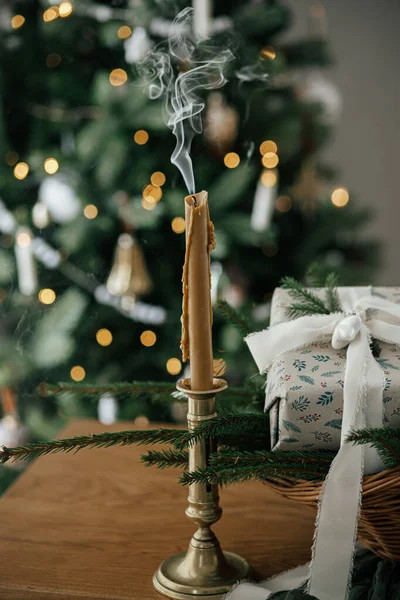时尚的蜡烛 包装的圣诞礼物 带有冷杉枝条的乡村篮子 与装饰过节日的树木在丑闻的鸟类房间里 喜怒无常的大气图像 圣诞快乐 节日快乐 — 图库照片