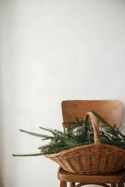 在斯堪的纳维亚的房间里 用冷杉树枝和木椅上的灯靠着乡村墙壁的时髦乡村篮子 圣诞快乐 节日快乐 圣诞乡村静谧的生活 — 图库照片
