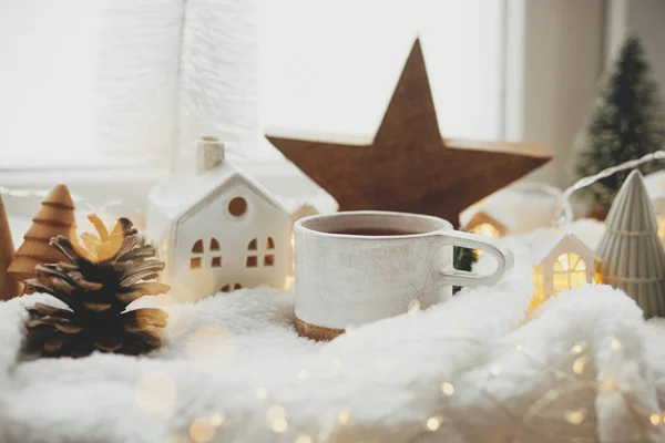 ウィンター衛生 現代かわいいクリスマスの家 松の円錐形 木の星および木 窓の柔らかい暖かい毛布の金色のライトが付いている茶のスタイリッシュなコップ クリスマスの居心地の良い生活 メリークリスマス — ストック写真