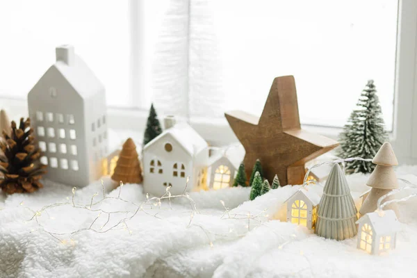 大气微型冬季村 时尚可爱的小陶瓷房子 柔软的雪毯上挂满了闪亮的灯光的圣诞树 圣诞现代白色背景 假期快乐 — 图库照片