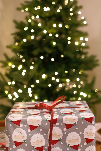 お祝いのライトが付いているクリスマス ツリーに対するスタイリッシュな包まれたクリスマスのギフト 大気圏のクリスマスイブ 休日の時間 メリークリスマス — ストック写真