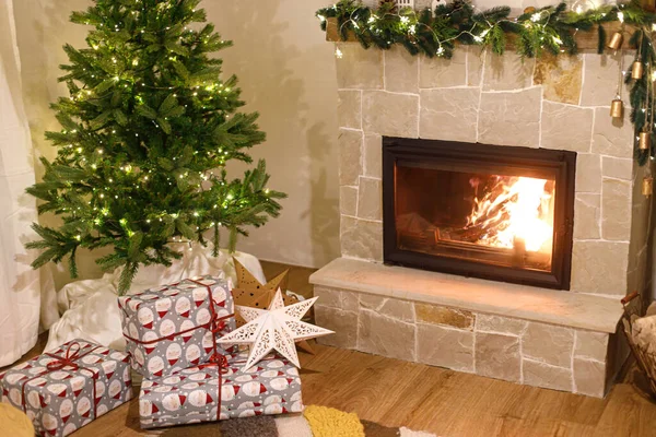 メリークリスマス スタイリッシュな包まれたクリスマスギフト お祝いのライトと居心地の良い燃える暖炉付きのクリスマスツリー 大気のクリスマスイブ 休日の時間 — ストック写真