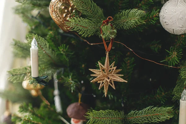 ヴィンテージゴールデンバブルとキャンドル付きのスタイリッシュな装飾クリスマスツリー 大気の冬の休日の準備 枝にぶら下がる現代のクリスマスの装飾 — ストック写真