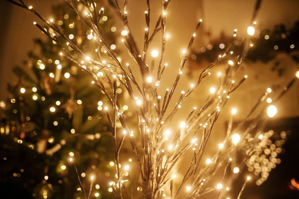 スタイリッシュなクリスマスは 金色のライトボケの背景に木を照らし 木を装飾し 夜の部屋で暖炉を燃やしました 暖炉で大気魔法のクリスマスイブ — ストック写真