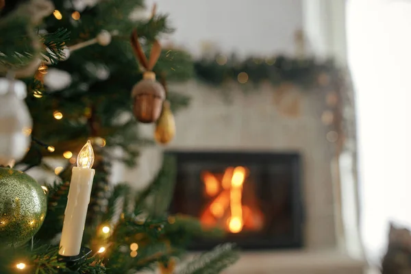 木のスタイリッシュなクリスマスキャンドルは暖炉に近づきます ヴィンテージの装飾 リボン ライトで美しい装飾されたクリスマスツリー クリスマスの背景 メリークリスマス — ストック写真