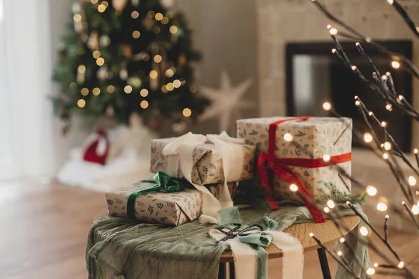 빈티지 소박한 벽난로와 조명으로 크리스마스 트리의 배경에 테이블에 리본과 크리스마스 — 스톡 사진