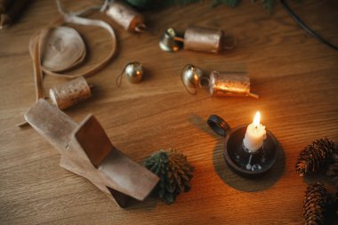 Mum, yıldız, kozalak, akşam festivalinde ahşap masada çanlar. Noel kırsal çelengi detaylarını hazırlıyorum. Kış tatili hazırlıkları, atmosferik zaman