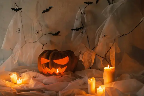 Mutlu Cadılar Bayramı! Korkunç Jack o fener oyulmuş balkabağı, örümcek ağı, hayalet, yarasalar ve akşamları parlayan ışık. Korkunç atmosferik cadılar bayramı partisi dekorasyonları, yazı için yer. Şaka mı şeker mi?