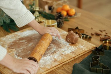 Elleri zencefilli ekmek hamurunu oklavayla yoğurur, baharat pişirir, köy masasında şenlik süsleri hazırlar. Noel kurabiyesi yapan kadın, tatil zamanı.