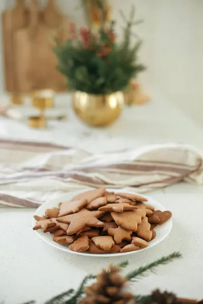 在温暖的阳光下 用冷杉枝条 松果和餐巾纸装饰在现代台面上的美味姜饼盘 制作新鲜的圣诞姜饼 节日气氛 — 图库照片