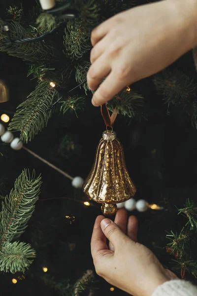木の枝にヴィンテージの装飾を掛ける居心地の良いセーターの手が近づいています スタイリッシュなバブルでクリスマスツリーを飾ります 大気の冬の休日の伝統 家族の時間 — ストック写真