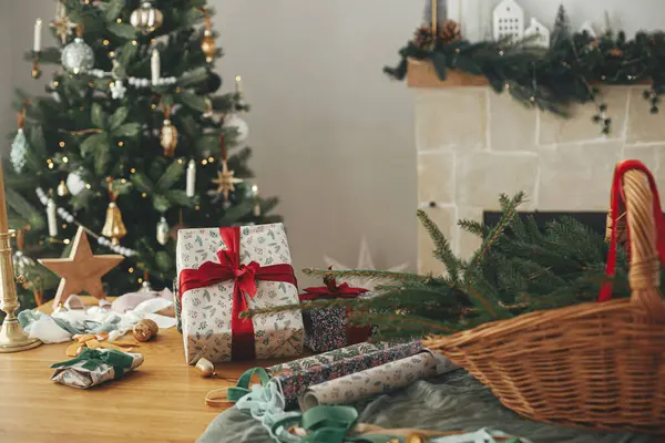 美しいヴィンテージクリスマスツリーと暖炉の背景にあるテーブル上のスタイリッシュなクリスマスギフトとお祝いの装飾 メリークリスマスとハッピーホリデー 冬休みの準備について — ストック写真