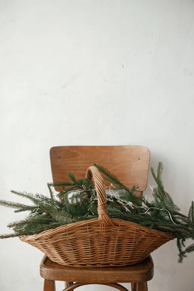 在斯堪的纳维亚的房间里 用冷杉树枝和木椅上的灯靠着乡村墙壁的时髦乡村篮子 圣诞快乐 节日快乐 圣诞乡村静谧的生活 — 图库照片