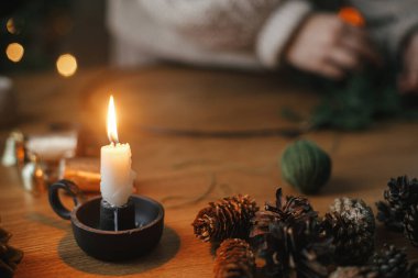 Mum, kozalak, çan, akşam şenliği odasındaki ahşap masada twinq. Noel kırsal çelengi detaylarını hazırlıyorum. Kış tatili hazırlıkları, atmosferik zaman