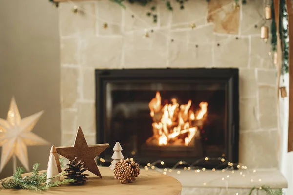 圣诞快乐 节日快乐 时尚的圣诞节木树 松果和冷杉枝条放在桌子上 挡住燃烧的壁炉 客厅里的现代乡村环保装潢 — 图库照片