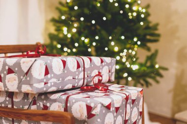 Şık bir Noel hediyesi Noel ağacına karşı şenlikli ışıklarla paketlenmiş. Atmosferik Noel arifesi, tatil zamanı. Mutlu Noeller.!