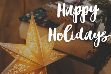 Altın Noel yıldızı ve Noel hediyeleri üzerine Mutlu Tatiller mesajı. Mutlu noeller. Sezonun tebrik kartı. El yazısı işareti