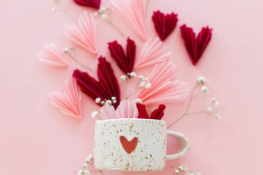 Sevgililer Günün kutlu olsun! Pembe ve kırmızı kalpler, çiçekler ve pembe arka planda kalbi düz olan modern kupa. Sevgililer Günü 'nün kağıt kesiği ve kupası. Aşk ve Anneler Günü