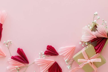 Sevgililer Günün kutlu olsun! Pembe ve kırmızı kalpler, çiçekler ve hediye kutusu pembe arka planda yatıyordu, mesaj için yer vardı. Sevgililer Günü kartı ve el işi kutusu. Aşk ve Anneler Günü