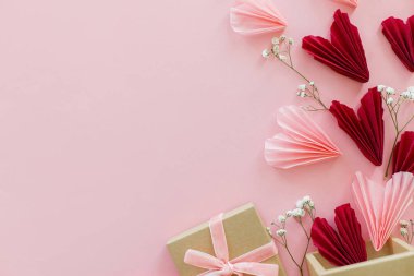 Sevgililer Günün kutlu olsun! Pembe ve kırmızı kalpler, çiçekler ve hediye kutusu pembe arka planda yatıyordu, mesaj için yer vardı. Sevgililer Günü kartı ve el işi kutusu. Aşk ve Anneler Günü
