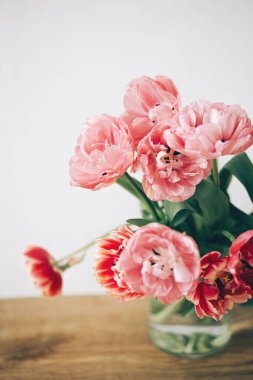 Kırsal arka planda vazodaki güzel laleler. Şık bir çiçek buketi. Sevgililer günün kutlu olsun ve anneler günün kutlu olsun. Yumuşak pembe ve kırmızı çiçekler