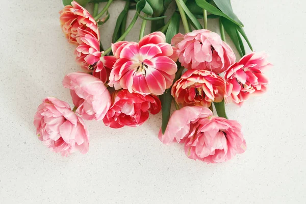 Beautiful tulips flat lay on grey stone background, space for text. Stylish floral bouquet. Happy Valentines day and happy mother\'s day. Tender pink and red flowers wallpaper