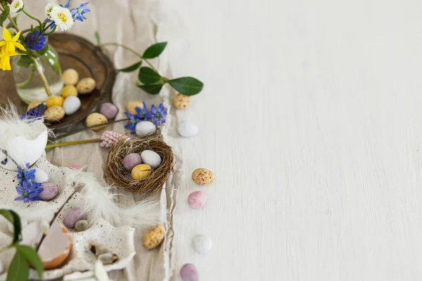Yuvada Renkli Paskalya Çikolatası Yumurtaları Bahar Çiçekleri Tüyler Ahşap Masa — Stok fotoğraf