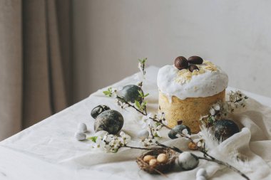 Paskalya yumurtaları, panettone, bahar çiçekleri ve çarşaf örtüsü üzerinde çikolata yumurtaları. Doğal boya mermer yumurtalar ve kiraz çiçekleri, asgari yaşam. Mutlu Paskalyalar!