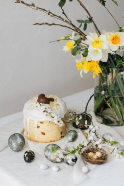 Paskalya yumurtaları, panettone, bahar çiçekleri ve çarşaf örtüsü üzerinde çikolata yumurtaları. Doğal boya mermer yumurtalar ve kiraz çiçekleri, asgari yaşam. Mutlu Paskalyalar!