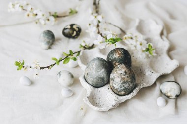 Paskalya yumurtaları ve kır masasında bahar çiçekleri. Mutlu Paskalyalar! Doğal boya mermer yumurtalar tepside ve kiraz çiçeklerinde. Mutlu Paskalyalar! Tatil için en az yaşam süresi