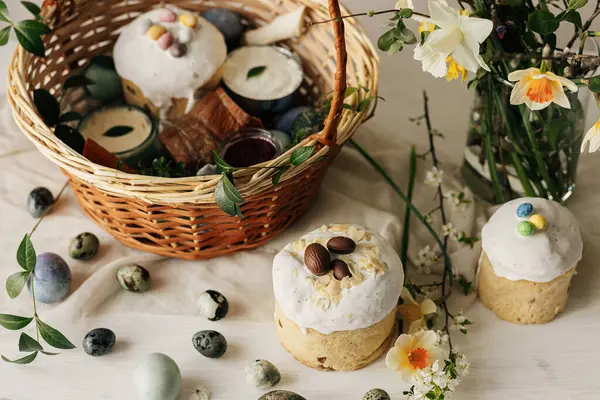 ハッピーイースター 自然な染められた卵 バター ビート そして素朴なテーブルの春の花が付いているスタイリッシュなイースターバスケット 伝統的なイースター正統派の休日の食べ物とダフデールの花束 — ストック写真