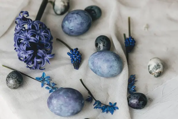 Mutlu Paskalyalar! Paskalya yumurtaları ve bahar çiçekleri kırsal masada keten peçete üzerinde. Doğal boyalı mermer ve mavi yumurta, sümbül çiçekleri ve keten peçete. Modern minimal düz yatak