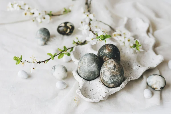 Paskalya yumurtaları ve kır masasında bahar çiçekleri. Mutlu Paskalyalar! Doğal boya mermer yumurtalar tepside ve kiraz çiçeklerinde. Mutlu Paskalyalar! Tatil için en az yaşam süresi