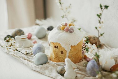 Mutlu Paskalyalar! Paskalya yumurtaları, pasta, tavşanlar, kır masasında kiraz çiçekleri. Modern doğal boyanmış yumurta, bayram yemeği ve bahar çiçekleri. Paskalya kırsalında hayat