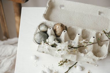 Mutlu Paskalyalar! Paskalya yumurtaları tepside ve kiraz çiçekleri kırsal masada. Modern doğal boya mermer yumurtalar ve bahar çiçekleri natürmort. Kırsal Paskalya Kompozisyonu