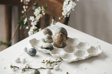 Mutlu Paskalyalar! Paskalya yumurtaları tepside ve kiraz çiçekleri kırsal masada. Modern doğal boya mermer yumurtalar ve bahar çiçekleri natürmort. Kırsal Paskalya Kompozisyonu