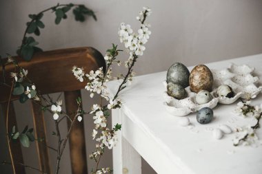 Mutlu Paskalyalar! Paskalya yumurtaları tepside ve kiraz çiçekleri kırsal masada. Modern doğal boya mermer yumurtalar ve bahar çiçekleri natürmort. Kırsal Paskalya Kompozisyonu