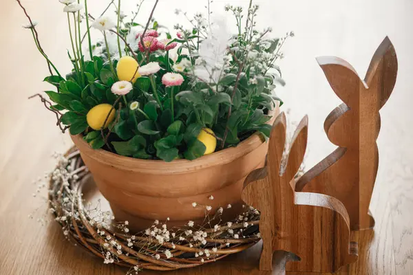 Stilvolle Ostereier Mit Federn Frühlingsblumen Und Hasenfiguren Auf Einem Holztisch — Stockfoto