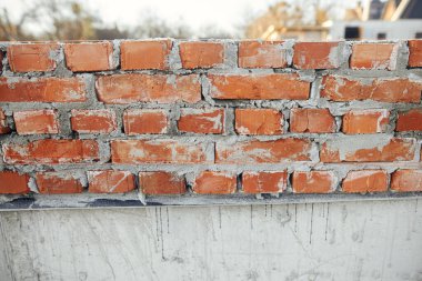 Beton temeli çimento kaplı tuğlalar, ev inşa süreci. Beton temeller üzerine döşenmiş kırmızı tuğlalar. İnşaat alanında inşaat malzemeleri