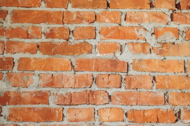 Bricks wall masonry close up with cement. Process of house building and building materials concept. Red bricks laying at construction site. Brick wallpaper pattern