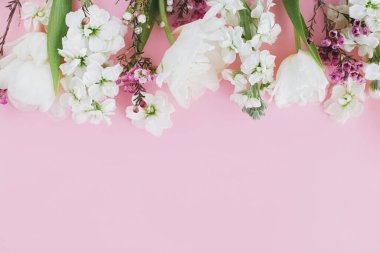 Anneler Günün ve Kadınlar Günün kutlu olsun. Pembe arka planda düzleşmiş şık beyaz çiçekler, metin için boşluk. Güzel yumuşak laleler ve bahar çiçekleri sınırı, tebrik kartı şablonu. Çiçek bayrağı