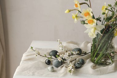 Paskalya yumurtaları ve kır ağacından yapılmış masa üzerinde bahar çiçekleri. Paskalya modern basit dekorasyon, doğal boyanmış mermer yumurtalar. Mevsimler selamlar. Mutlu Paskalyalar!