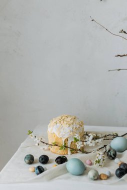 Paskalya yumurtaları, panettone ve bahar çiçekleri kırsal masada keten kumaş üzerinde. Doğal boya yumurtaları ve kiraz çiçekleri, şenlik için asgari yaşam. Mutlu Paskalyalar!