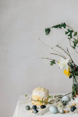 Paskalya yumurtaları, panettone ve bahar çiçekleri kırsal masada keten kumaş üzerinde. Doğal boya yumurtaları ve kiraz çiçekleri, şenlik için asgari yaşam. Mutlu Paskalyalar!