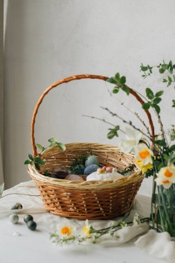 Mutlu Paskalyalar! Doğal boyanmış yumurta, et, ekmek, tereyağı, pancar ve bahar çiçekleriyle süslü Paskalya sepeti. Geleneksel Paskalya Ortodoks bayramı yemekleri ve nergisler buketi