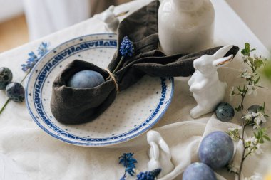 Paskalya sofrası çok şık. Tavşan peçetesinde paskalya yumurtası ve kırsal masada bahar çiçekleri. Mutlu Paskalyalar! Doğal boya mavi yumurta ve mor hiacynt. Tatil için en az yaşam süresi