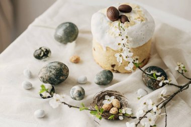 Paskalya yumurtaları, panettone, bahar çiçekleri ve çarşaf örtüsü üzerinde çikolata yumurtaları. Doğal boya mermer yumurtalar ve kiraz çiçekleri, asgari yaşam. Mutlu Paskalyalar!